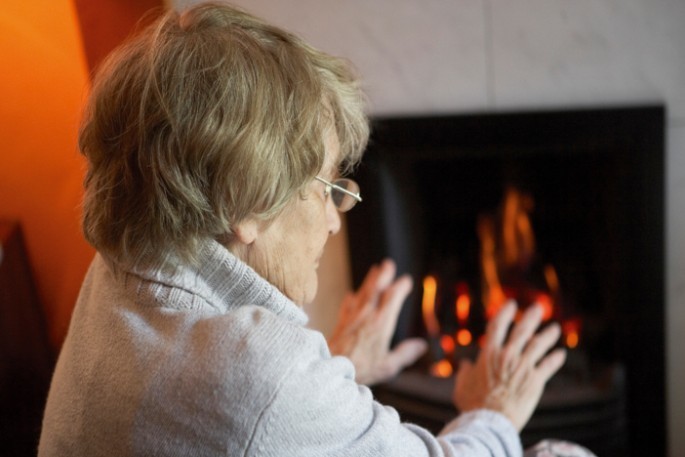 Old lady with hands by fire